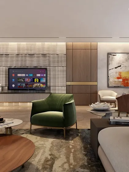A living area in a Nagpur apartment where every detail is a nod to luxury living. Opulent grey and Dover white marble gleam under natural light, while a sophisticated wood veneer media wall adds timeless charm, harmonizing with modern aesthetics and a bold green armchair.