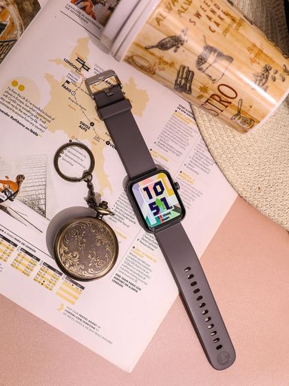 A flat-lay composition featuring the boAt Xtend Plus smartwatch. Paired with travel-themed props like a map and a pocket watch, this shot tells a story of adventure and modern convenience.