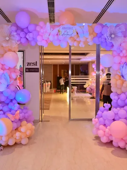 The grand entrance for Anaisha's butterfly-themed party. The pastel balloon arch welcomes guests into the magical celebration.