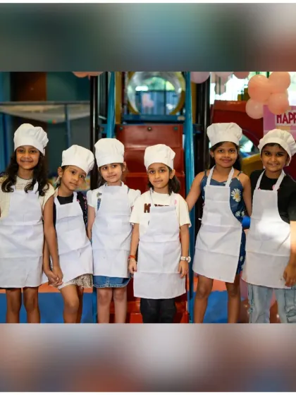 A group of proud little chefs in their hats and aprons, ready for their baking adventure to begin.
