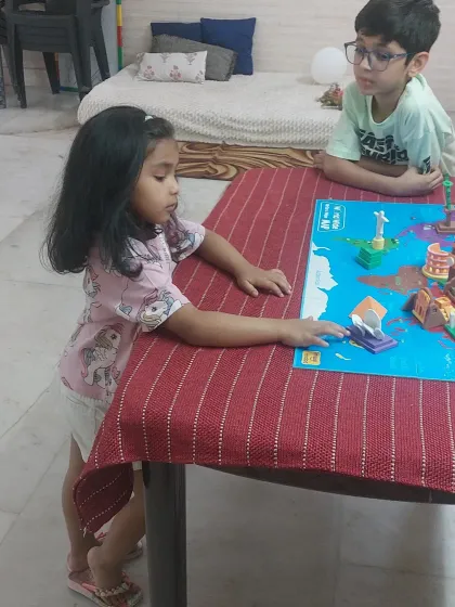 A student carefully places a monument on the world map. This hands-on approach helps children learn geography in a way they will remember.