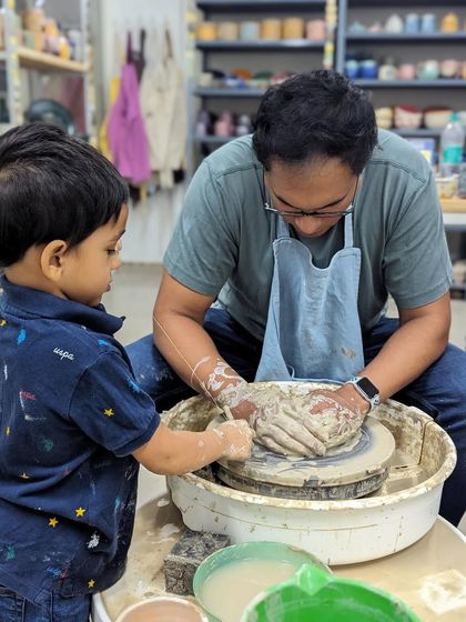 Pottery is a wonderful activity for parents and children to do together. This father-son duo is having a great time creating on the wheel.
