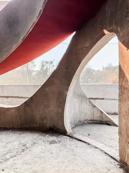 Sunlight streams through the curved openings of the "La La Land" structure, creating a beautiful play of light and shadow on the unfinished surfaces.