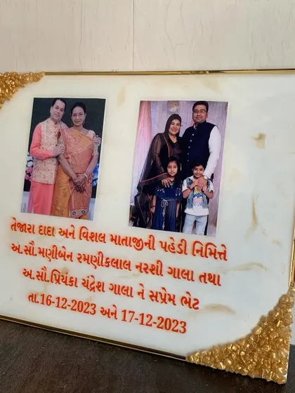This rectangular frame was created as a special gift, featuring two photos and a personalized message in Gujarati script. The corners are accented with a gold geode design.