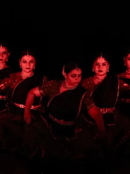 The intense red lighting in this scene from 'Ek Anant' reflects the fury and conflict of the battle sequences. The expressions of the dancers are key to conveying the drama.