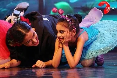 A quiet moment of connection amidst the energy of a stage performance. For me, teaching ballet is about building trust and sharing the joy of dance, one-on-one. This image captures the supportive bond I share with my young students.