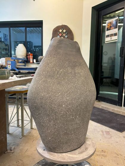 A large, hand-built vase in its raw, unfired state. The texture of the stoneware clay gives it a beautiful, rustic feel.