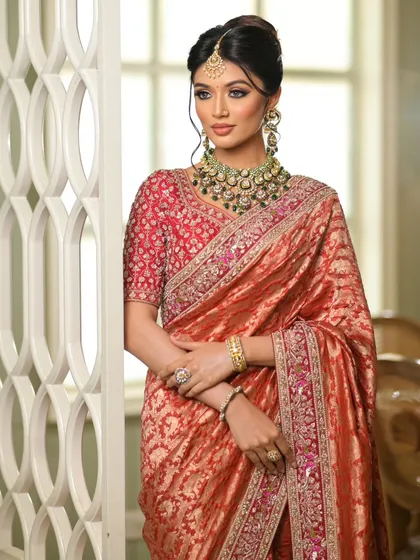 The rich red blouse pairs perfectly with the rust-colored saree. The drape is clean and allows for easy movement.