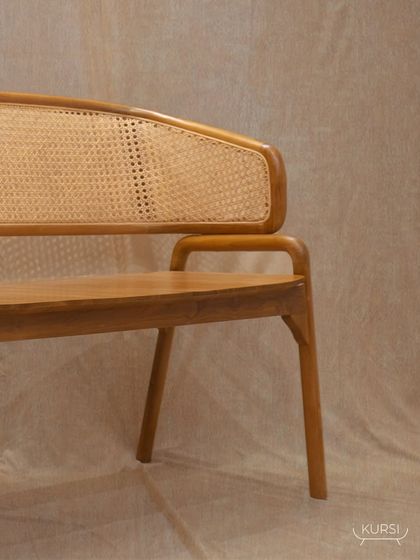 The 'Romanji' bench from another angle, showing the full length of the woven rattan backrest. It's a statement of artistry and quality for your home.