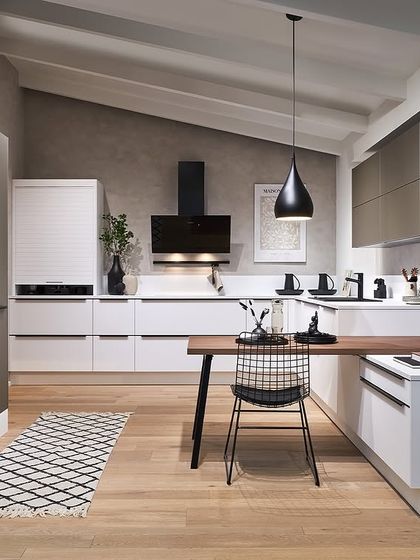 This design pairs crisp white lower cabinets with greige upper cabinets and a wood dining extension, creating a light and airy space with a touch of Scandinavian warmth.