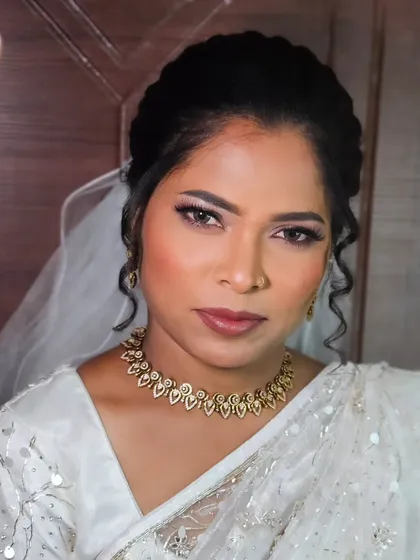 A stunning Christian wedding look with a white saree. The makeup is glamorous yet elegant, with defined eyes and a soft lip color that complements her skin tone.