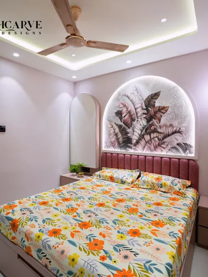 Another angle of the pink bedroom, showing the arched mirror that complements the headboard design.
