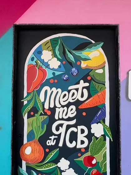 A close-up of the "Meet me at TCB" door art, highlighting the fun, hand-painted illustration style.