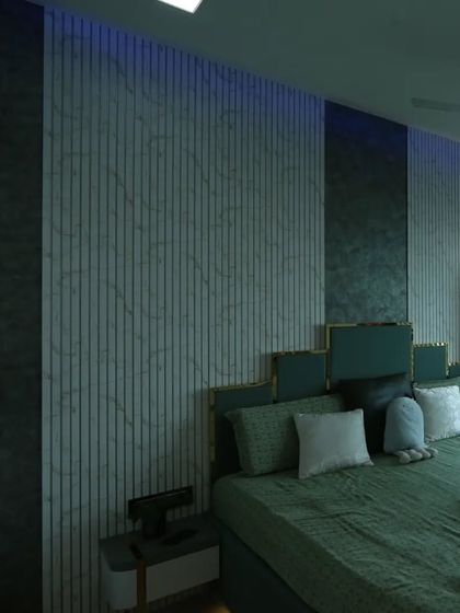 The feature wall behind the bed combines fluted panels with a textured marble finish, creating a sophisticated backdrop for the custom headboard.