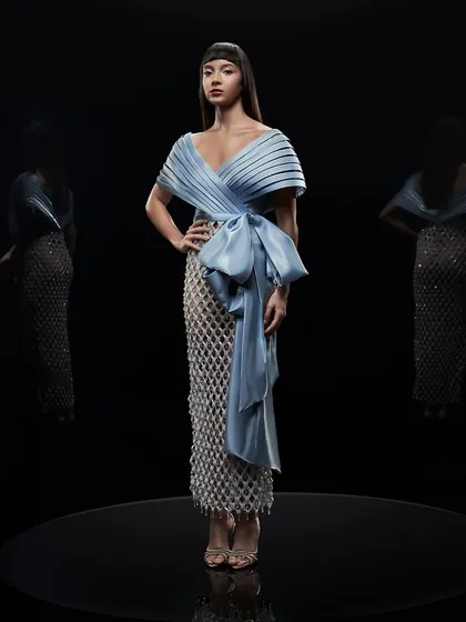 A full-length shot of an icy blue dress by Alpana Neeraj, set against a black background to emphasize its form.