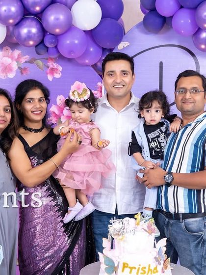 A happy family photo from a purple floral themed birthday party.