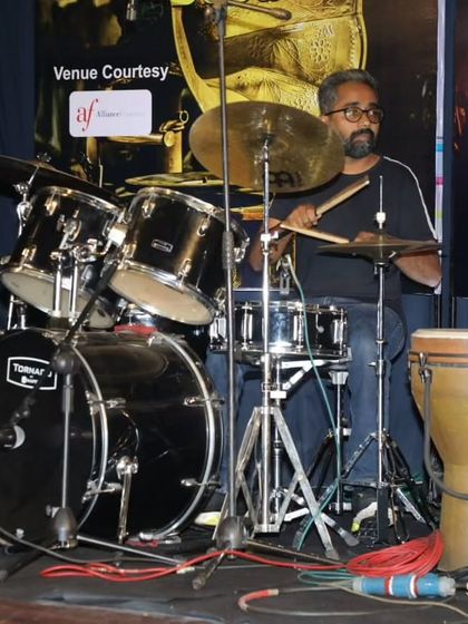 A side view of our adult drummer, fully engaged in the performance.