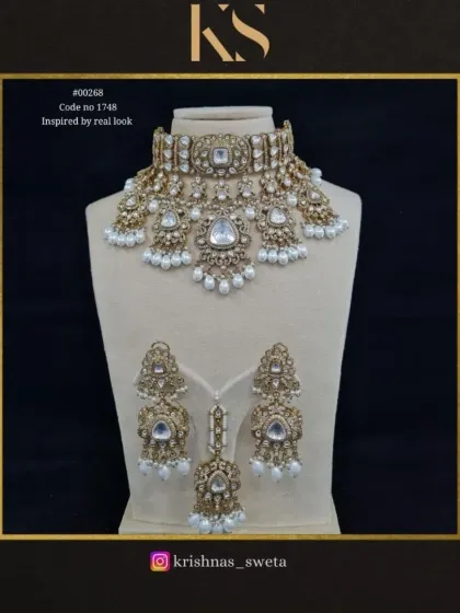 An exclusive Kundan bridal set inspired by a real-look design. This set includes a choker, earrings, and maang tikka with classic pearl drops.