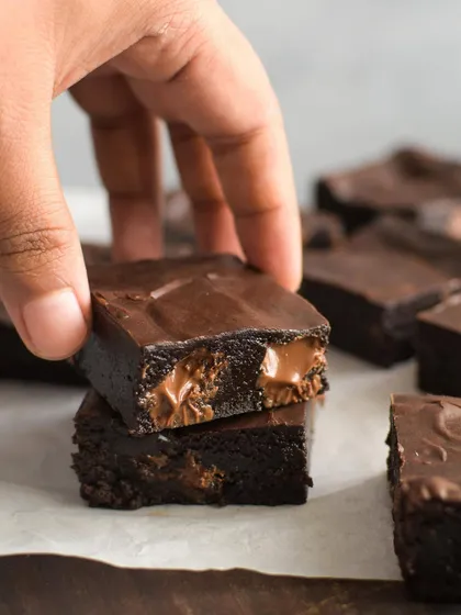 A stack of my gooey fudgy chocolate chip brownies. The melted chocolate chunks inside create pockets of molten goodness, making them incredibly decadent.