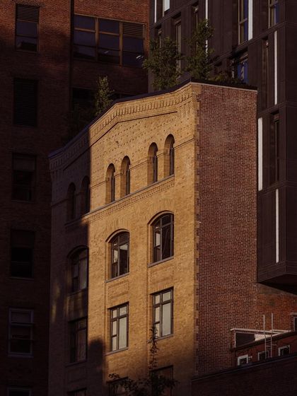 The warm light of golden hour hits a brick building in NYC. I'm constantly chasing this light, which can make even the most ordinary architecture look extraordinary.
