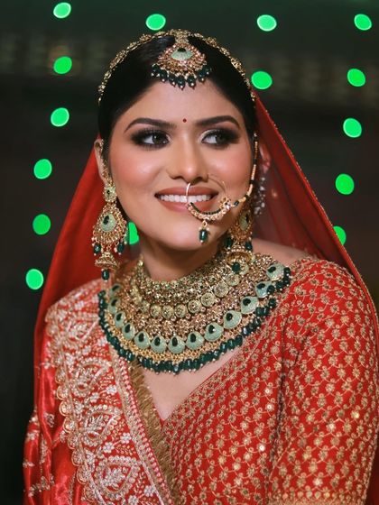 A bright, happy smile from a gorgeous bride. The green in her jewelry adds a beautiful contrast to her red outfit, and the makeup ties it all together for a harmonious look.