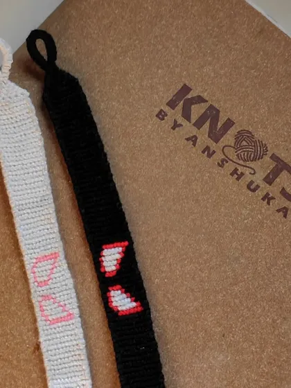 A side-by-side comparison of the black and white Spider-Man bracelets, along with a custom "DU" initial bracelet.