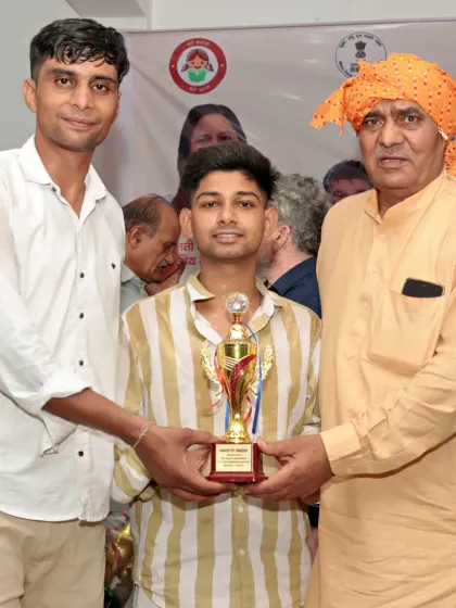 With a student holding his championship trophy. His victory is a victory for the entire academy.