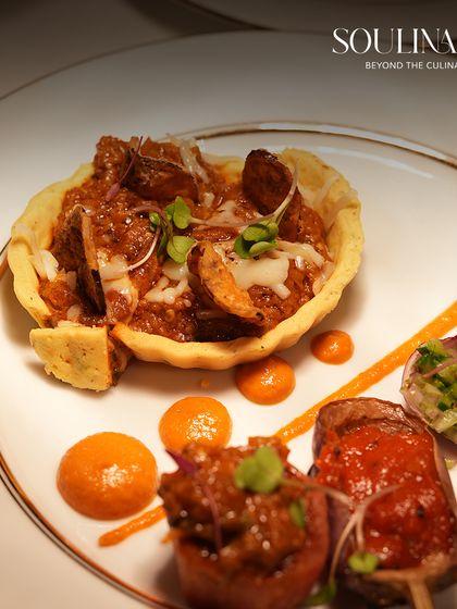An artfully plated appetizer featuring a savory tartlet and skewered bites, showcasing our attention to detail in wedding catering. Each dish is a small masterpiece, designed to delight the senses.