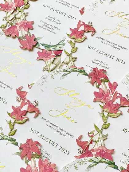 A pattern of the die-cut floral invitations. The repetition highlights the incredible detail of the 3D flowers and the elegance of the gold foil script.