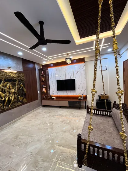We love blending traditional Indian elements with contemporary design. This living room features a classic wooden swing (julla) alongside a modern TV unit and a stunning 3D mural of Radha Krishna, creating a space that is both culturally rooted and stylish.