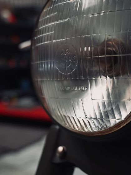 The classic headlamp of the 1955 Royal Enfield Bullet, a key piece of its vintage identity.