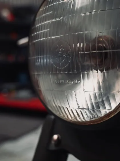 The classic headlamp of the 1955 Royal Enfield Bullet, a key piece of its vintage identity.