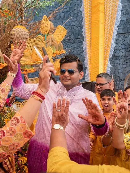 The groom makes a high-energy entrance, dancing with guests at the sunflower-themed Haldi.