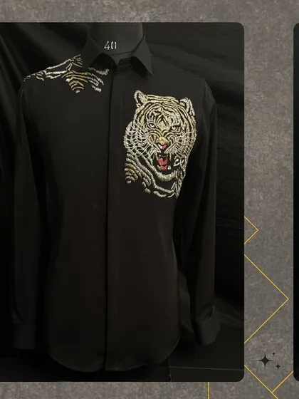 For the man who is unafraid to make a statement, I created this "ROAR" shirt. It features a powerfully embroidered tiger, meticulously detailed with metallic threads on a classic black shirt, blending wearable art with high fashion for a truly unique look.