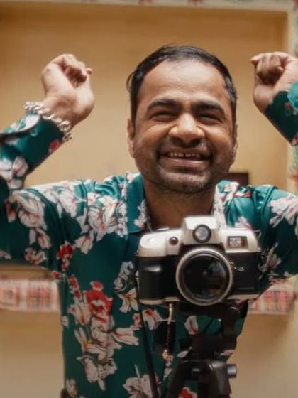 A joyful still from the Starsports IPL ad, where I styled the photographer character in a vibrant floral print shirt, fitting the festive wedding theme.