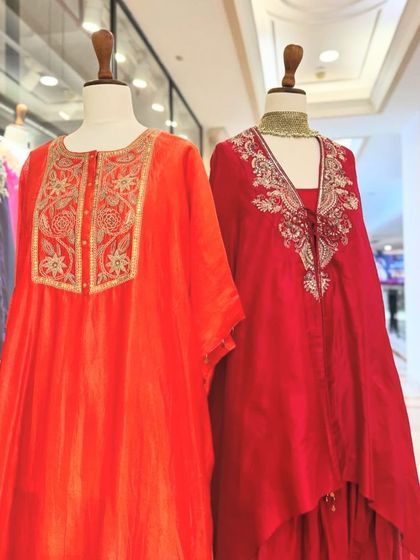A duo of vibrant red and orange kaftans with delicate gold embroidery, perfect for a glamorous festive look.