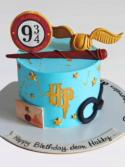 A minimalist Harry Potter-themed cake with iconic symbols like Platform 9 3/4, the golden snitch, and Harry's glasses. This is a stylish and modern take on the popular theme.