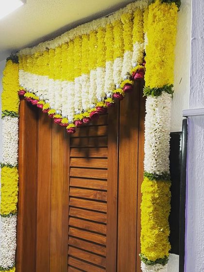 For an intimate home function, I decorated this doorway with a traditional floral arrangement. The design uses strings of yellow and white chrysanthemums with a touch of pink rose petals.