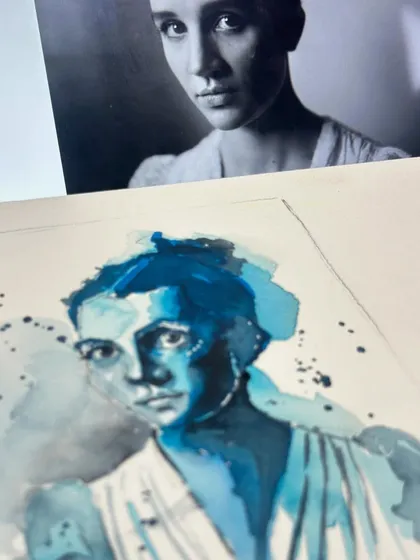 The process of creating a monochromatic blue portrait, with the reference photo visible on the screen behind my watercolour painting.