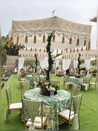 A view of the guest seating, with tables covered in a green leaf-print linen and topped with elegant umbrellas.