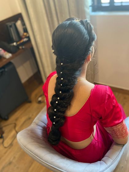 The back view of the Gujarati bridal braid, adorned with simple pearls for an elegant and classic finish.
