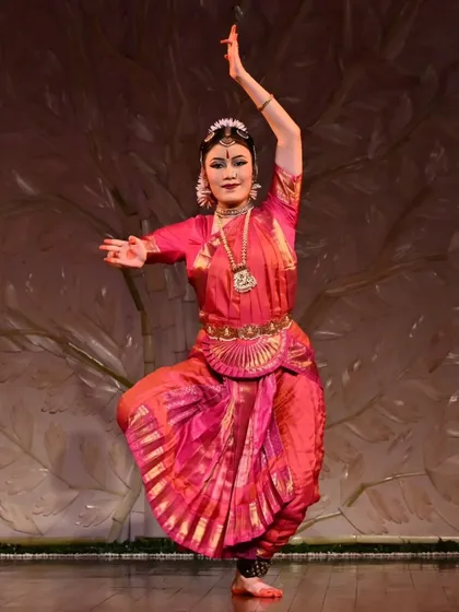 My shishya Stuti Mukherjee during her arangetram, a "Cinderella moment" of transformation. The stunning backdrop, crafted from carved banana stems, is a traditional art form from Vrindavan, adding a unique aesthetic to the performance.