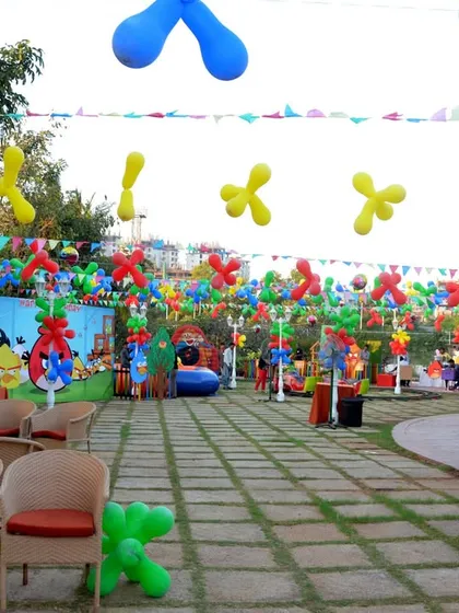 A wide view of an Angry Birds themed party, showing the colorful outdoor decor, character cutouts, and themed balloon arrangements.