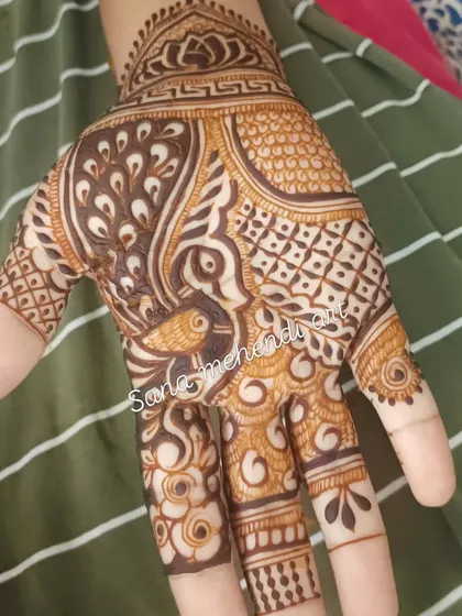 A simple peacock design on the palm, a quick and beautiful option for a guest.