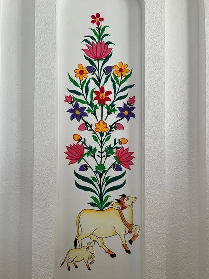 A detailed view of the central panel, featuring the holy cow and calf beneath a vibrant 'tree of life' design.