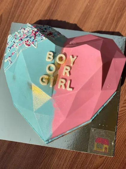 A "Boy or Girl?" gender reveal smash cake. The parents-to-be get to break the chocolate heart to find out the exciting news.