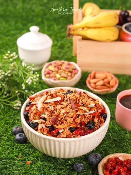 Another shot of the granola in a picnic-like setting. The wooden crate and fresh fruits create a wholesome, outdoor, and healthy lifestyle story around the product.