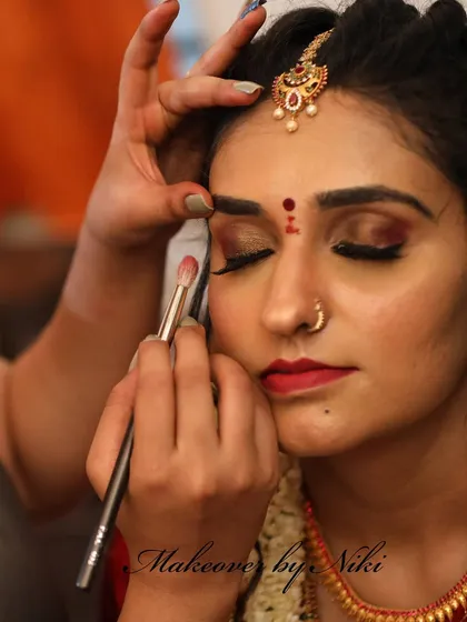 The art of makeup is in the details. Here, I am carefully applying eyeshadow and lipstick for Pooja, ensuring every element is perfect for her muhurtham.