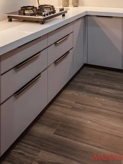 The details matter. This shot shows the handleless drawers and the beautiful contrast between the matte grey finish and the warm wooden flooring, creating a sophisticated and modern look.