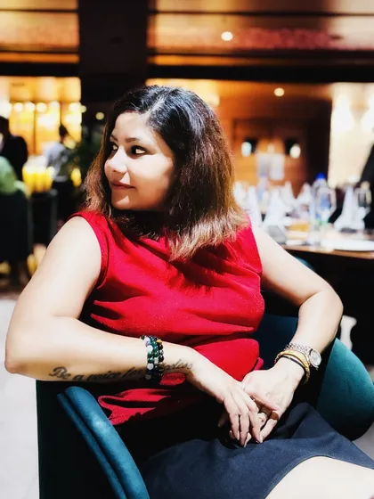 A candid shot from a birthday dinner, looking away from the camera with a soft smile.